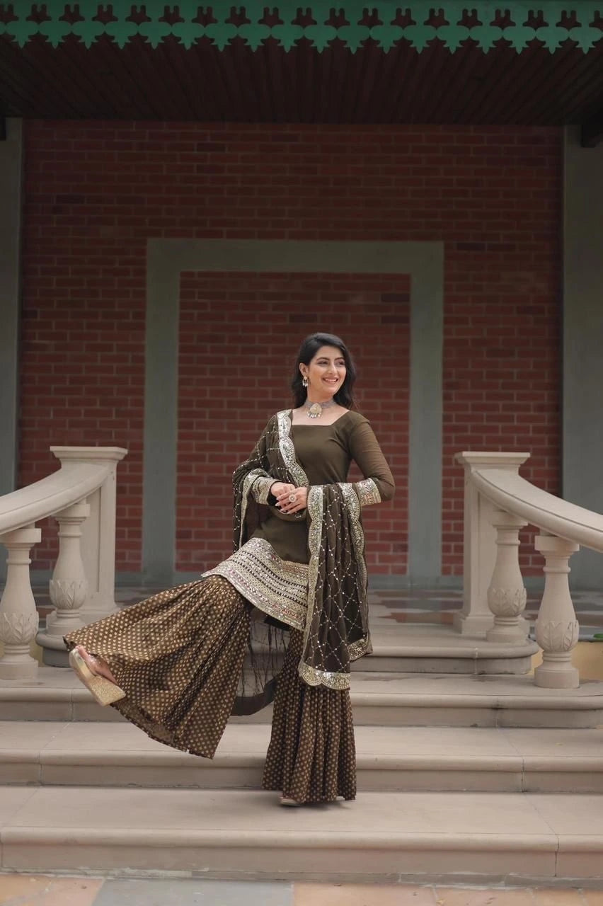 Woman in traditional attire standing on steps with a brick wall background