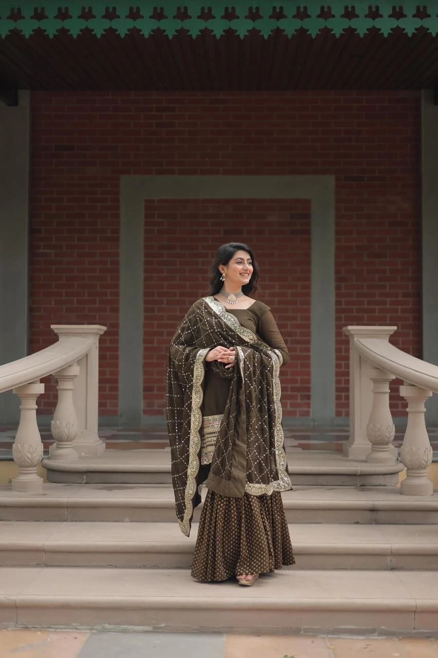 Woman in traditional attire standing on steps with a brick wall and decorative railing in the background