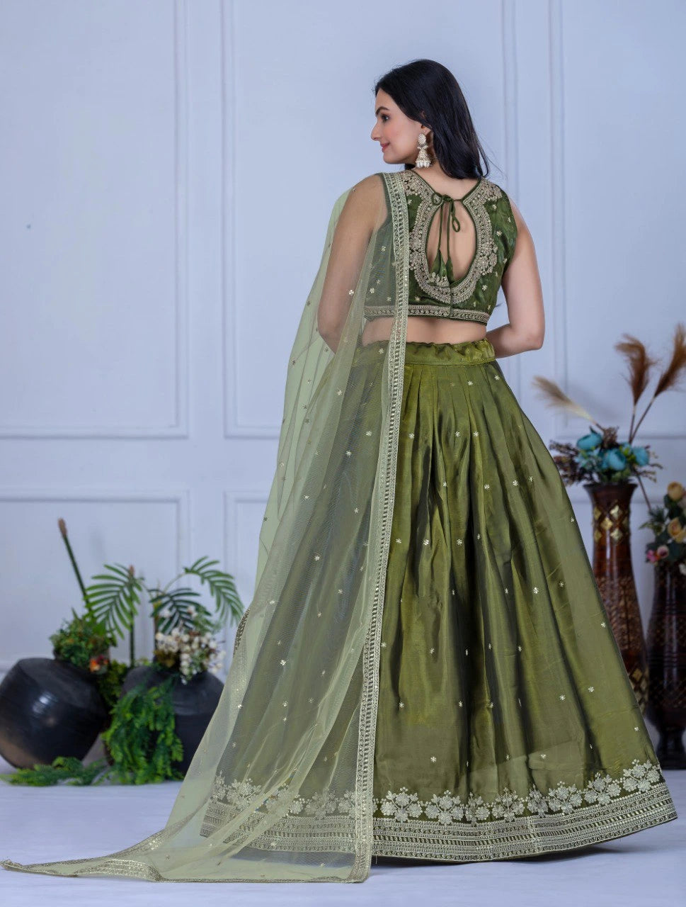 Woman wearing a green traditional outfit with a white background