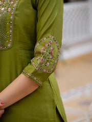 Green embroidered kurta with floral patterns on a blurred background