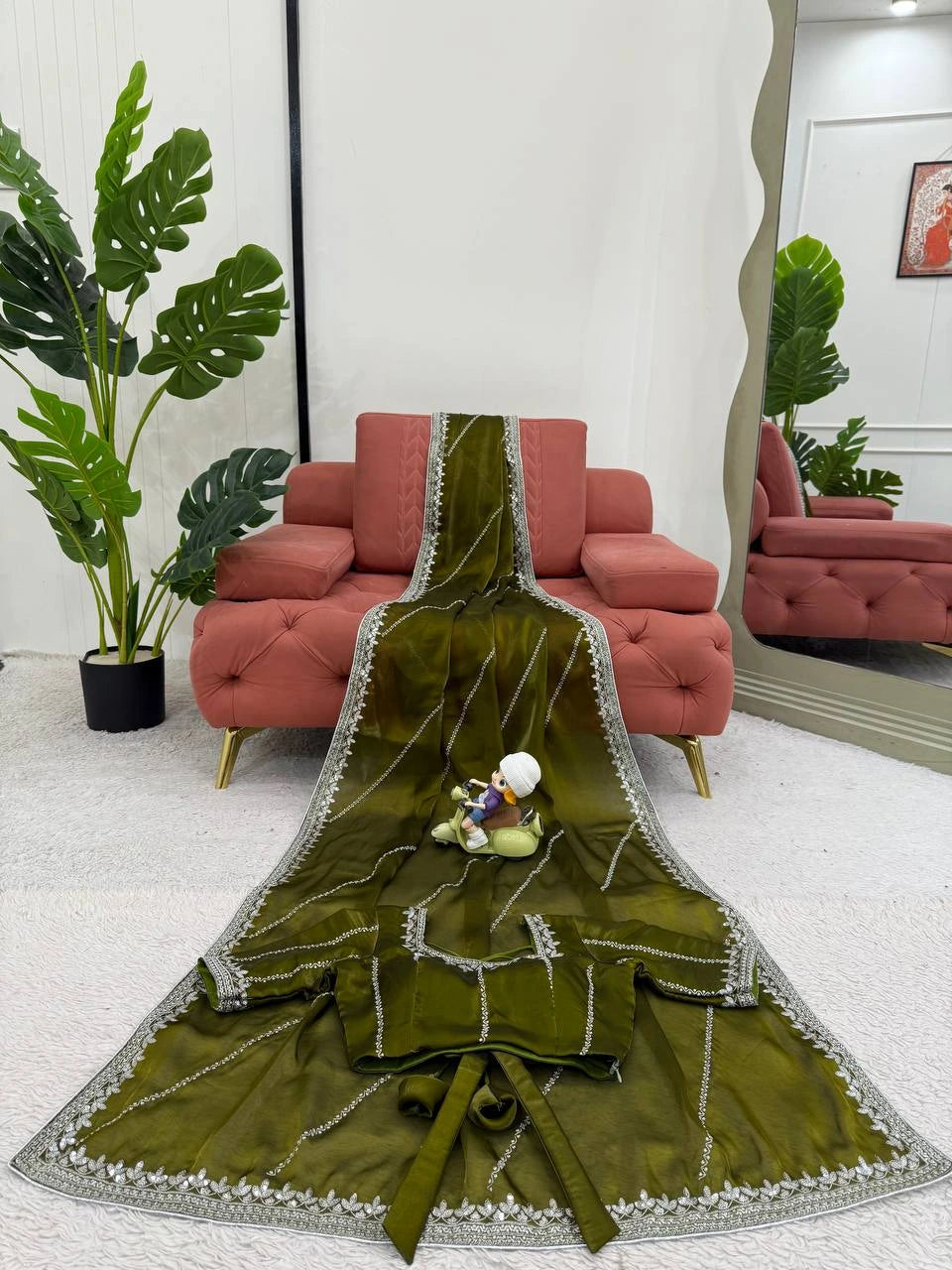 Green embroidered fabric with a decorative pattern on a white background