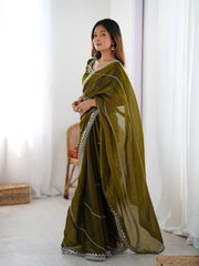 Woman wearing a green saree with a white background