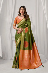Woman wearing a green and orange saree with a white curtain background