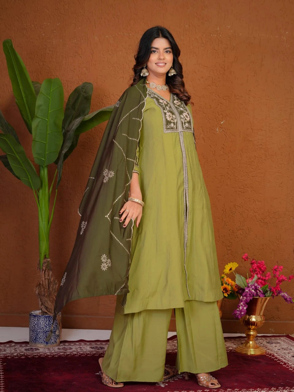 Woman in a green traditional outfit with a brown background