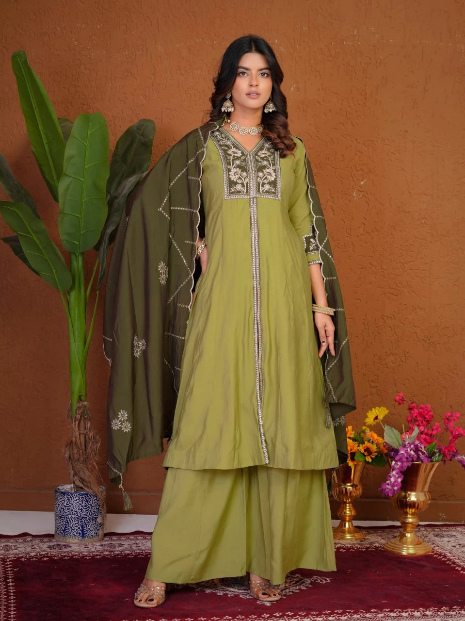 Woman wearing a green traditional outfit with a brown background