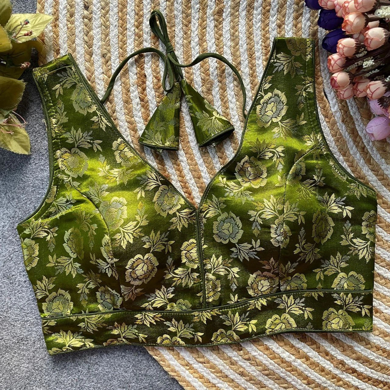 Green floral-patterned sports bra on a textured surface with flowers around