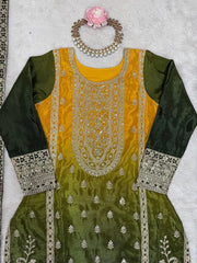 Green and yellow embroidered traditional outfit with jewelry on a light gray background