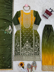 Green and yellow embroidered traditional outfit with jewelry and shoes on a light gray background