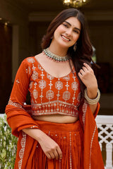 Close-up of orange embroidered choli with round neck and dense sequins zari geometric work