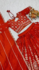 Flat lay close-up of orange embroidered choli showing sequins zari work and scalloped border detail