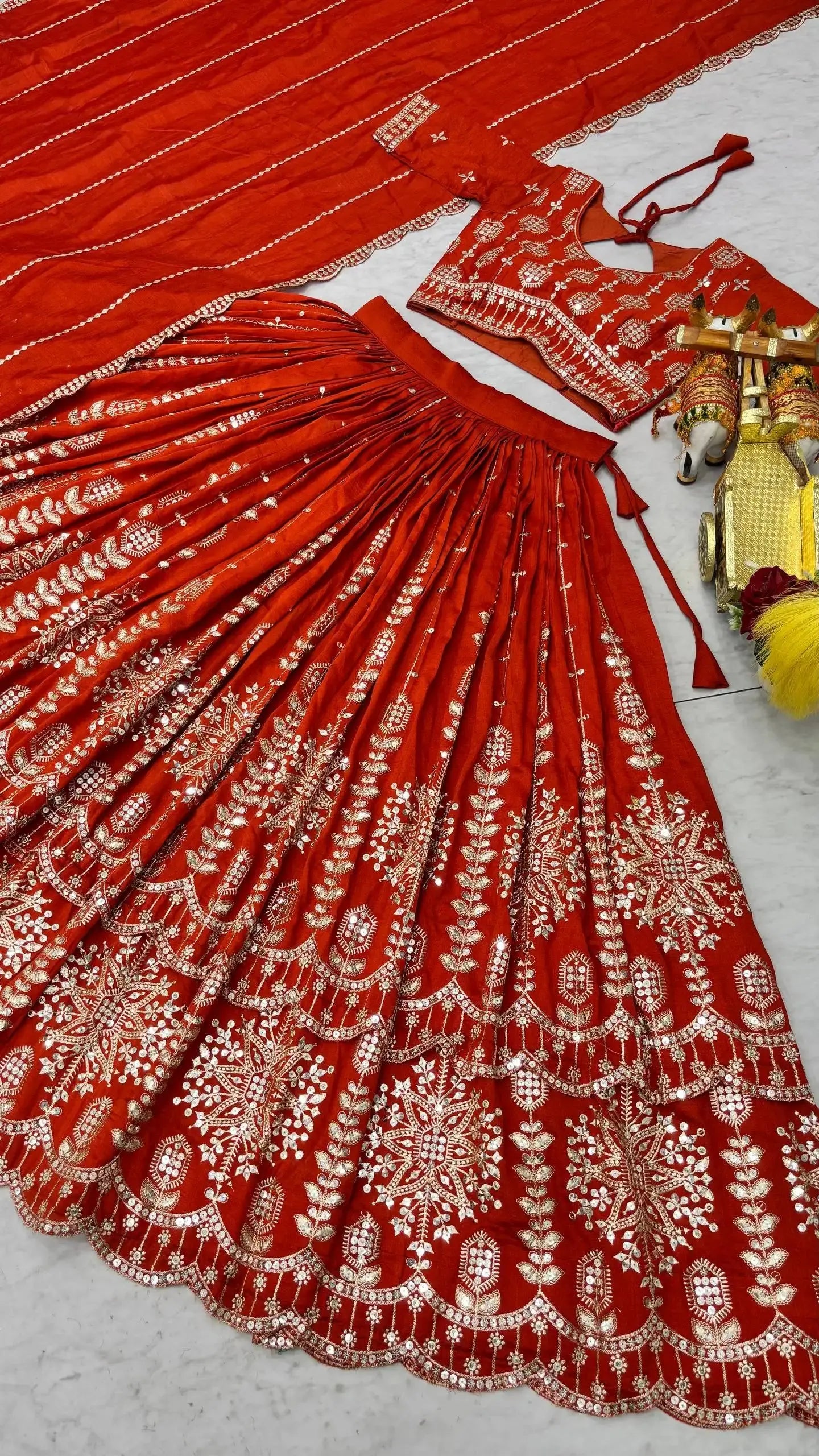 Flat lay of full orange sequins embroidered lehenga set with choli and dupatta