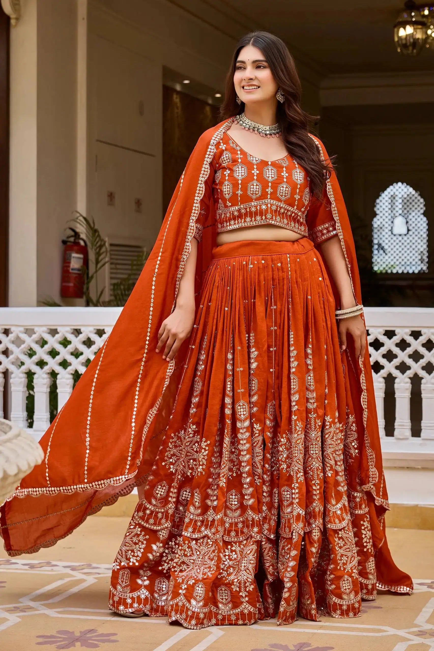 Orange sequins embroidered vichitra lehenga, front standing view with choli and matching dupatta
