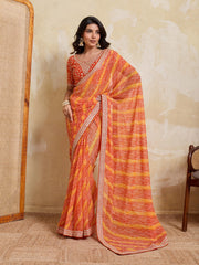 Woman wearing an orange and yellow saree with a neutral background