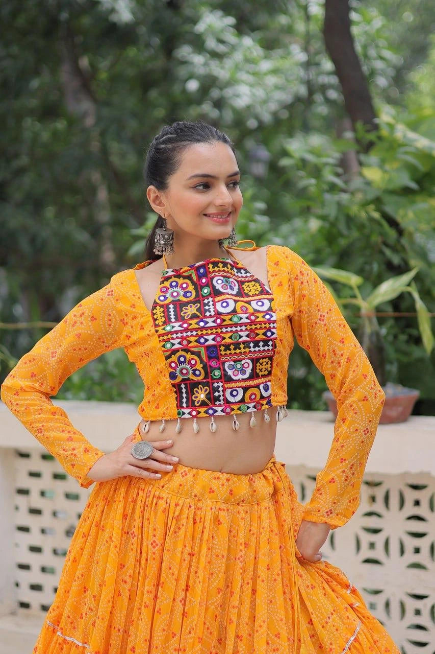 Woman wearing a traditional orange and multicolored outfit with a floral pattern, standing outdoors.