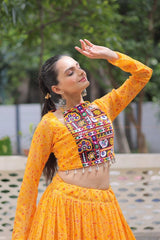 Woman in traditional orange and multicolored outfit with a blurred green background