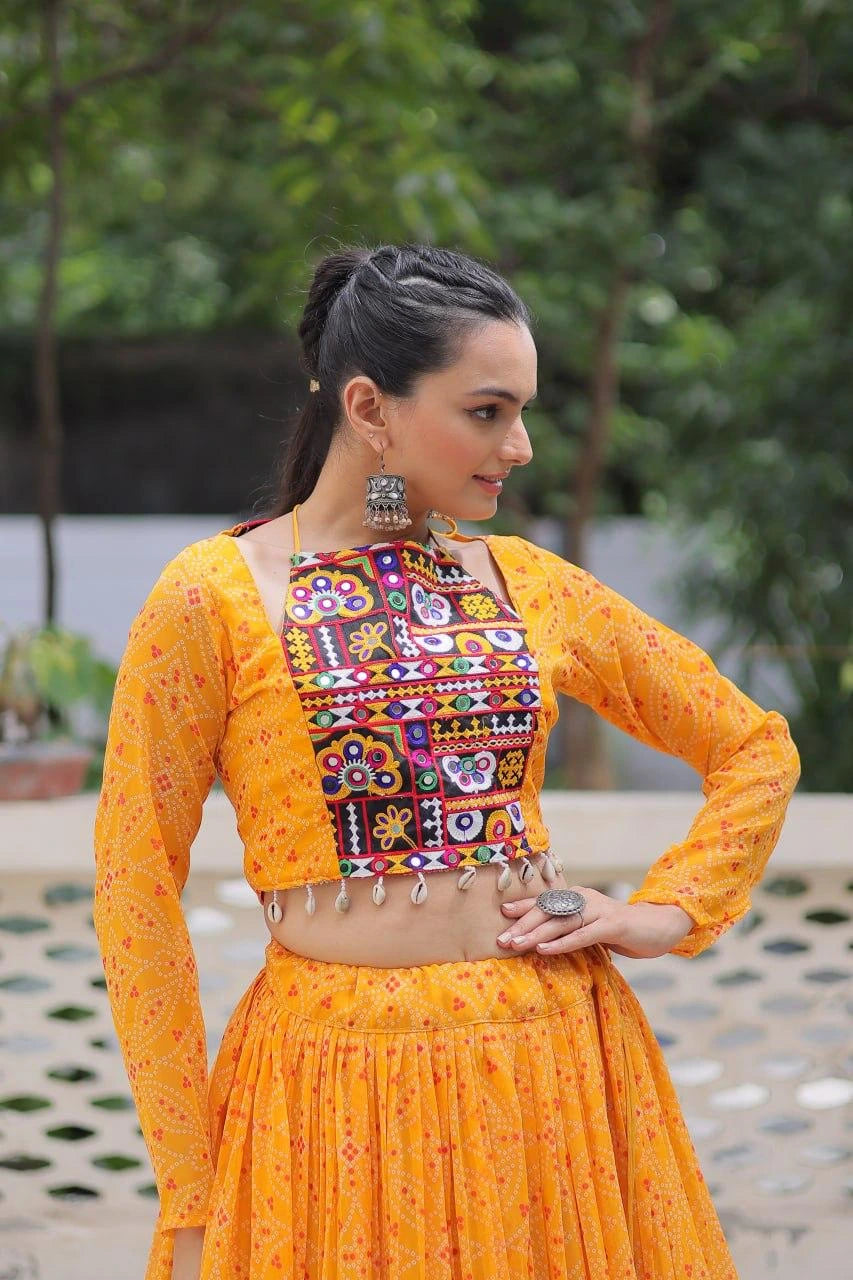 Woman wearing a traditional orange outfit with a colorful embroidered blouse outdoors.