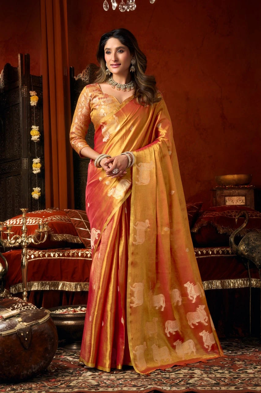 Woman in a traditional saree with elephant patterns in a decorated room.