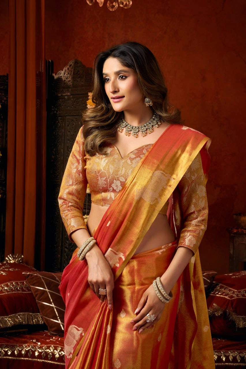 Woman in a traditional orange saree with a decorative background