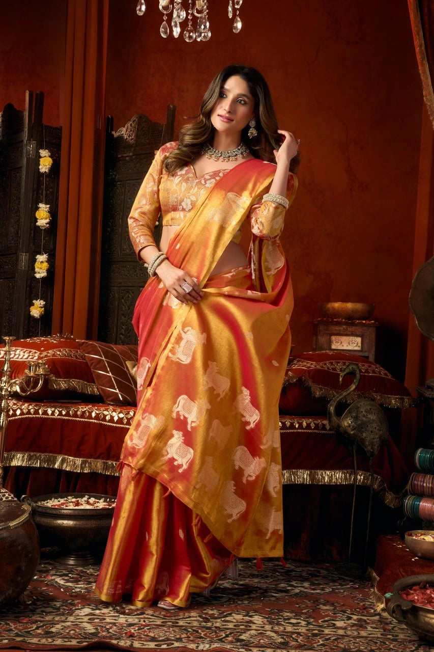 Woman in a traditional saree standing in an ornate room with decorative elements.