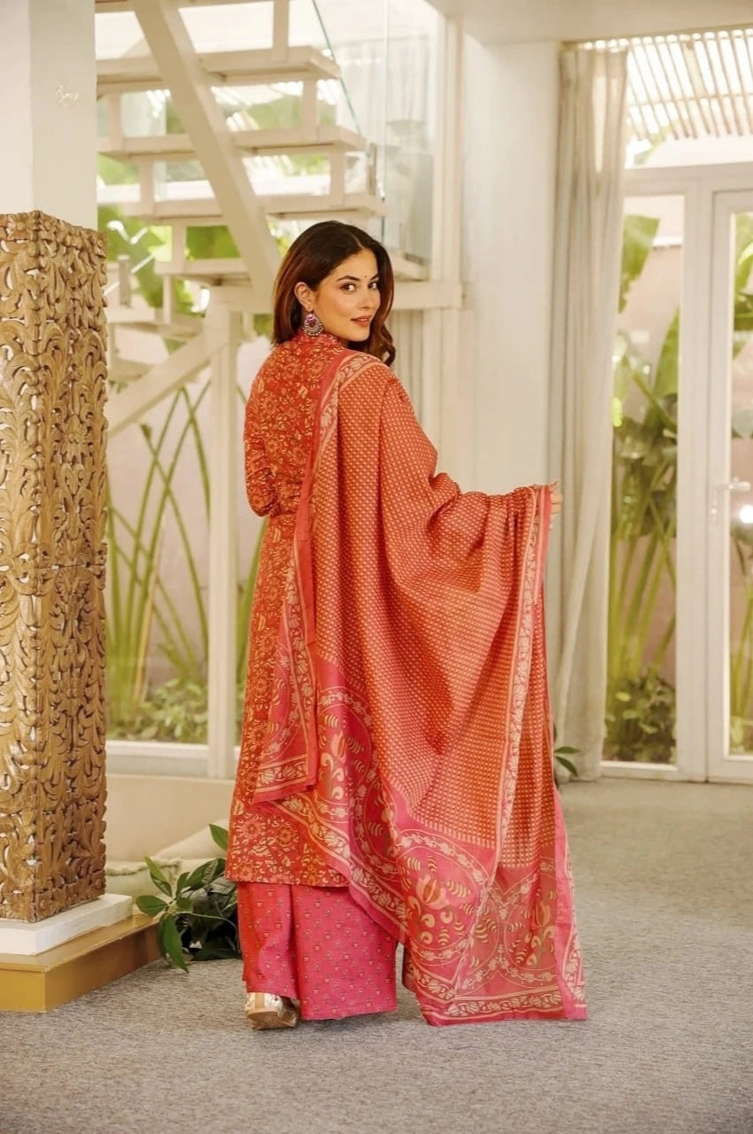 Woman in a traditional outfit with a red dupatta in an indoor setting