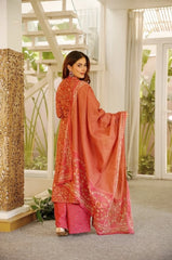Woman in a traditional outfit with a red dupatta in an indoor setting