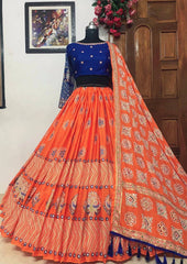 Traditional orange and blue outfit on a mannequin against a wooden door and wall.