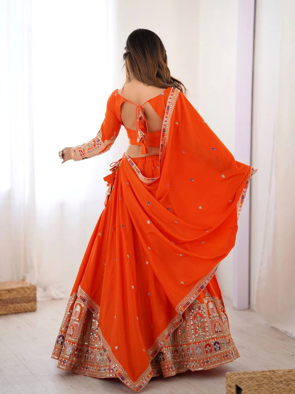 Orange saree with intricate patterns on a white background