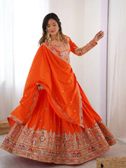 Woman wearing an orange embroidered saree with a white background