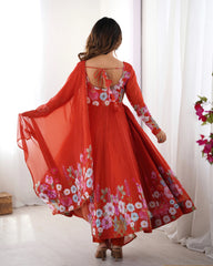 Woman wearing a red floral dress with a white curtain and flowers in the background
