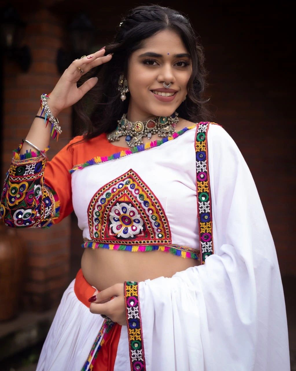 Woman wearing a colorful traditional outfit with intricate designs.
