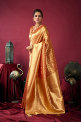Woman in a gold saree standing against a red background with decorative elements.