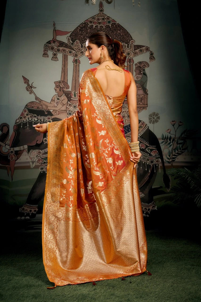 Woman in a traditional orange saree with a decorative backdrop