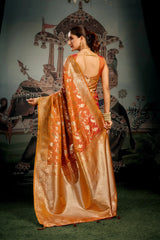 Woman in a traditional orange saree with a decorative backdrop