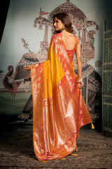 Woman in a vibrant orange and red saree with a decorative background