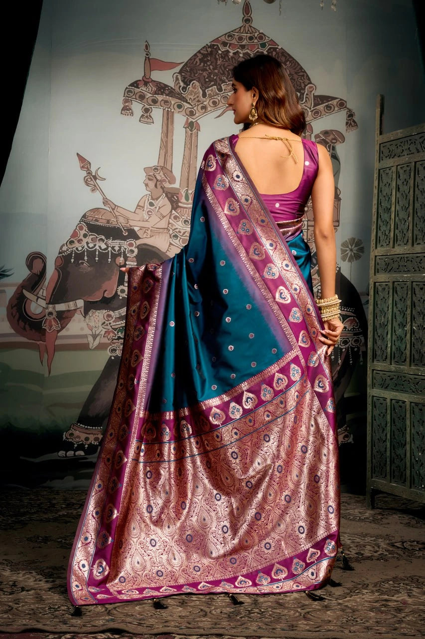 Woman in a traditional saree standing in front of an ornate wall.