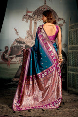 Woman in a traditional saree standing in front of an ornate wall.