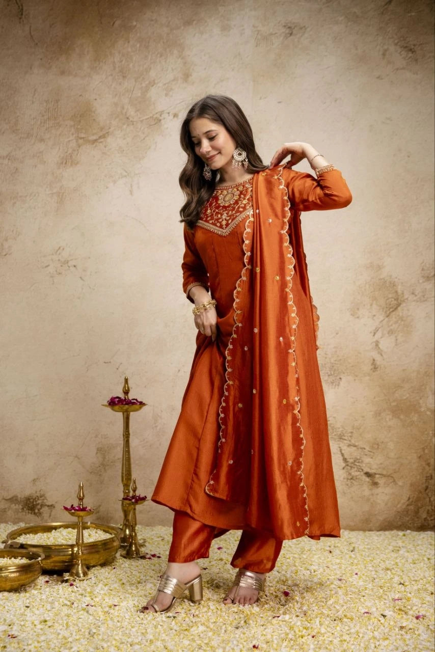 Woman in an orange traditional outfit with a textured wall background