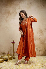 Woman in an orange traditional outfit with a textured wall background