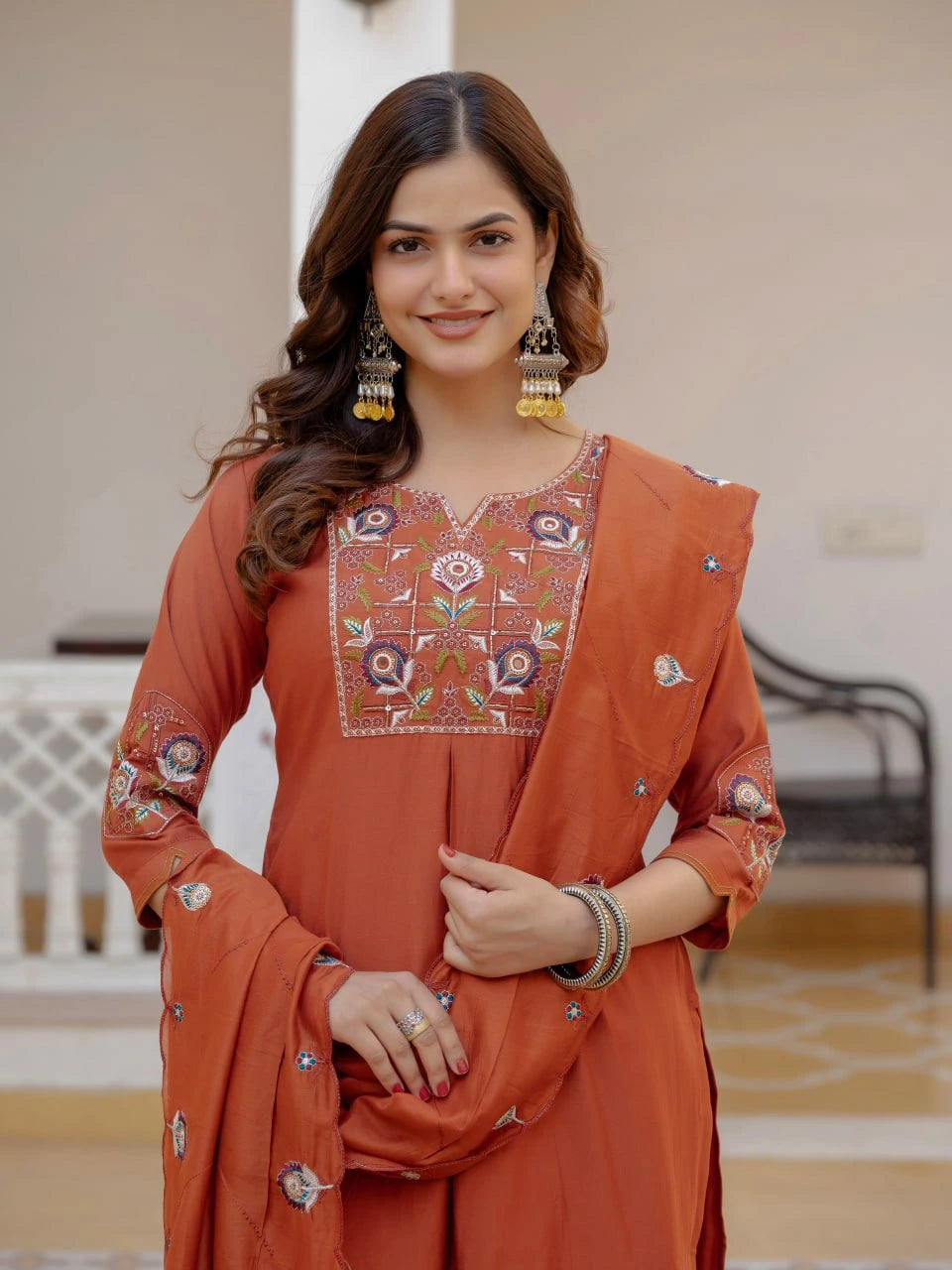 Woman wearing an orange embroidered traditional outfit with a blurred background