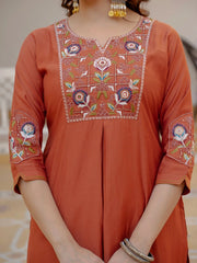 Orange embroidered dress with intricate patterns on a neutral background