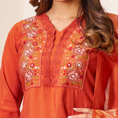 Orange embroidered traditional outfit with floral patterns on a plain background