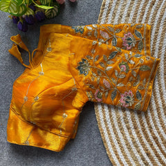Yellow traditional outfit with floral embroidery on a textured surface