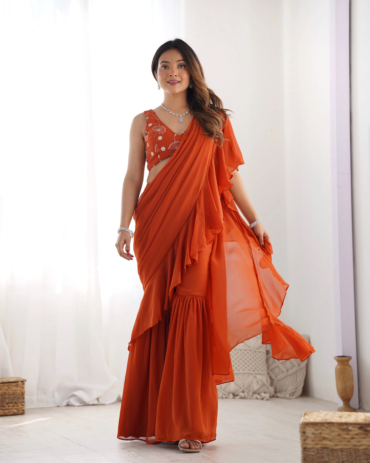 Woman wearing an orange saree with a white background