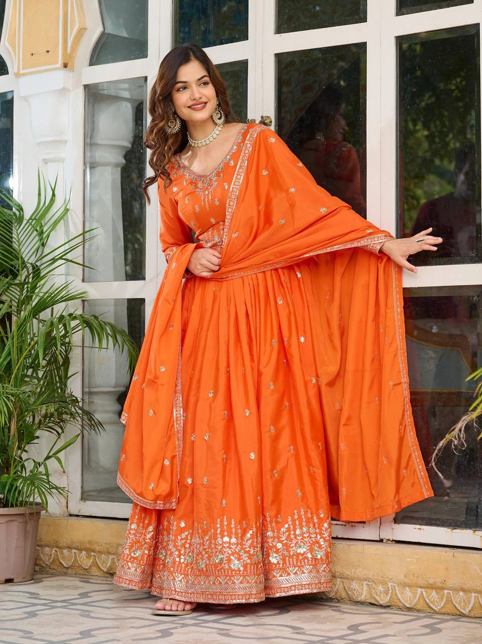 Detailed view of handcrafted orange American silk suit with shimmering sequins embroidery.