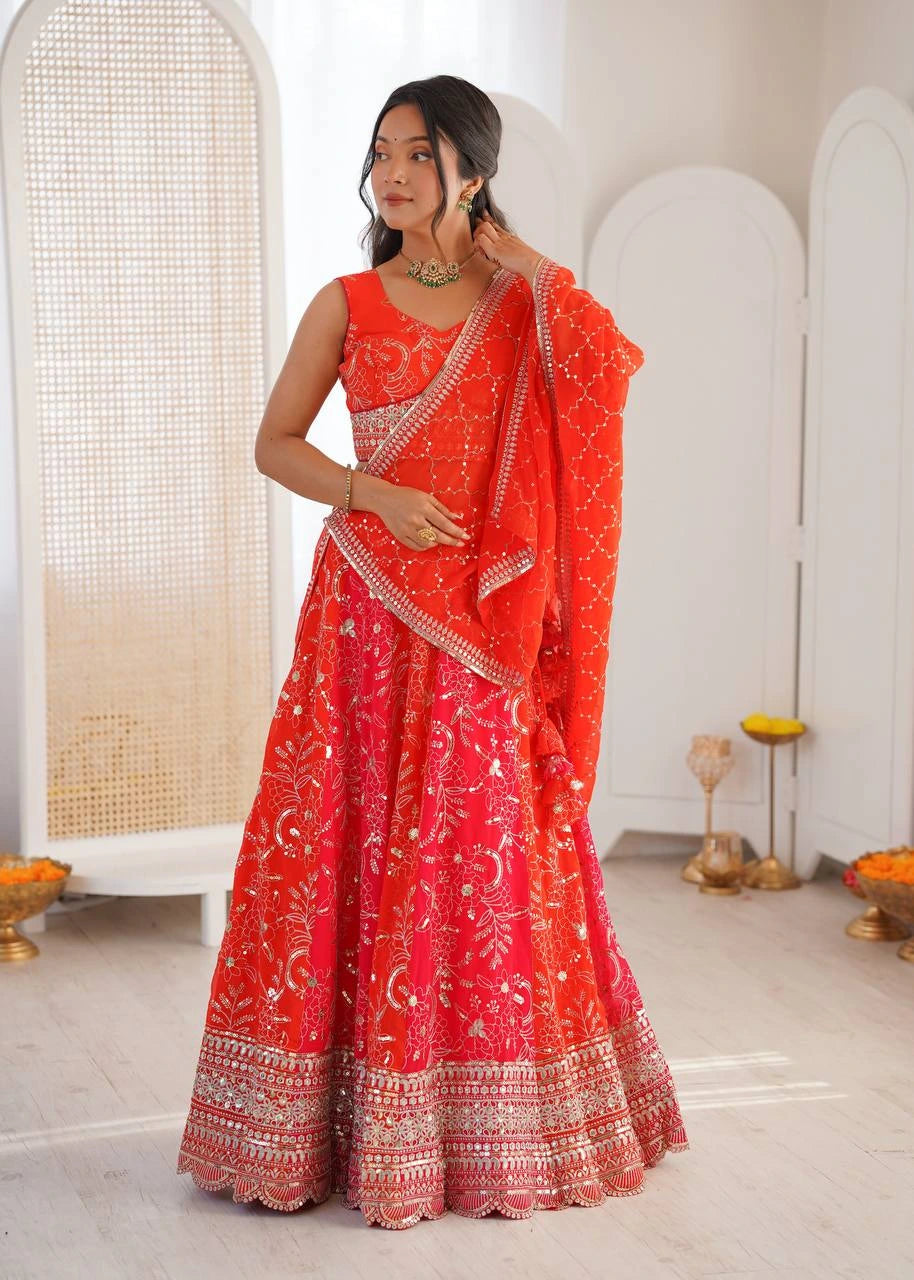 Woman wearing a red saree with white patterns in a minimalistic room.