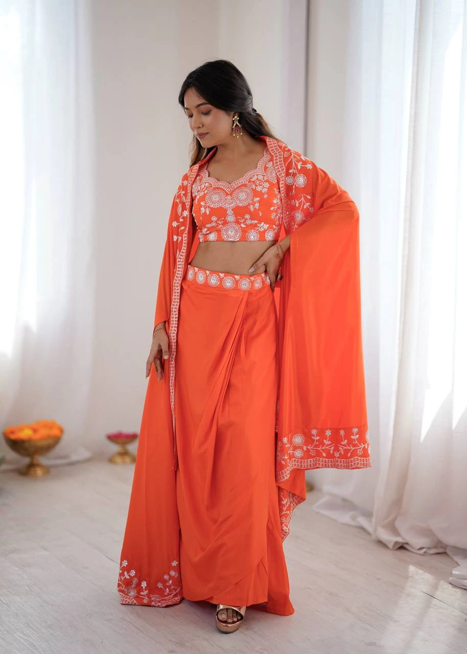 Woman wearing an orange traditional outfit with white patterns in a bright room.
