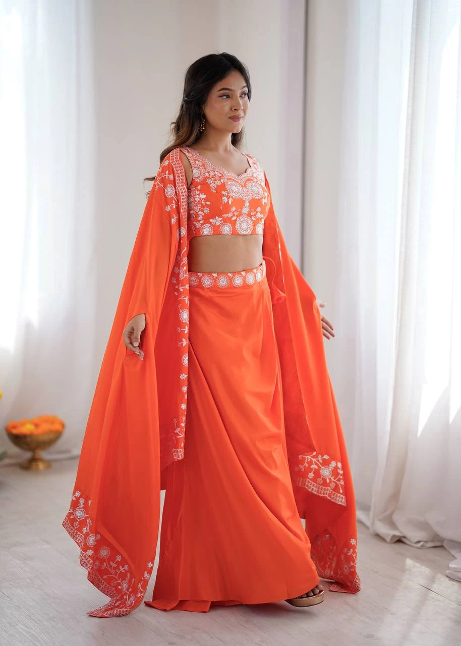 Woman wearing an orange traditional outfit with a white floral pattern indoors.