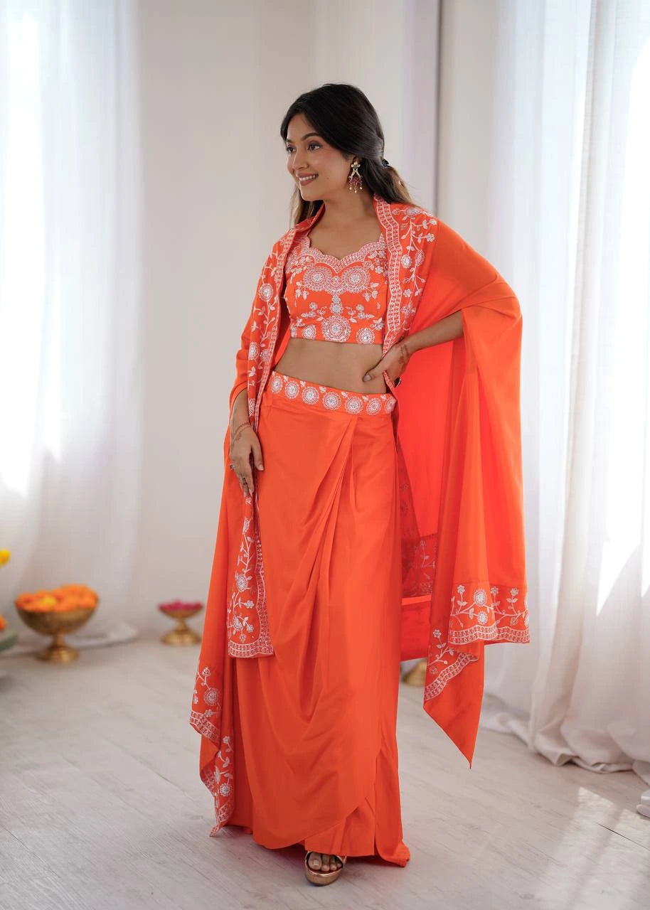 Woman wearing an orange traditional outfit with white patterns in a bright room.