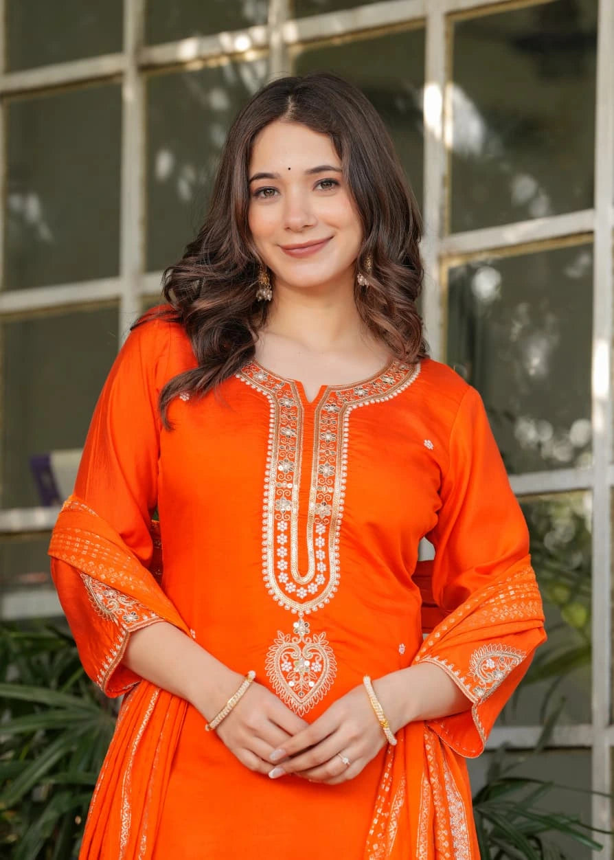 Close-up of orange silk kurti highlighting fine thread embroidery and zari craftsmanship.