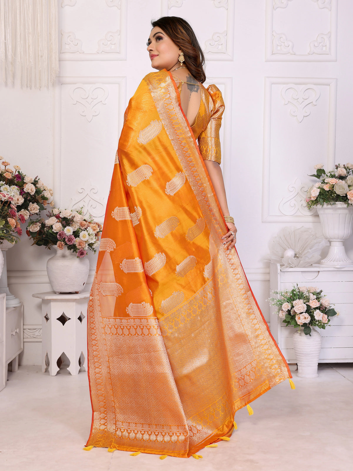 Woman wearing an orange saree with a white background